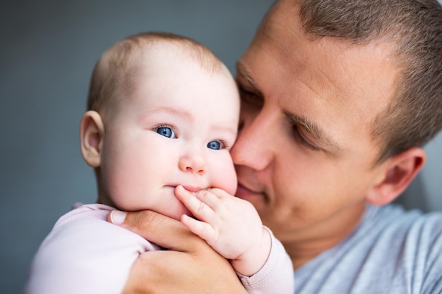 Close-up portret van jonge vader die schattige babymeisje thuis kust