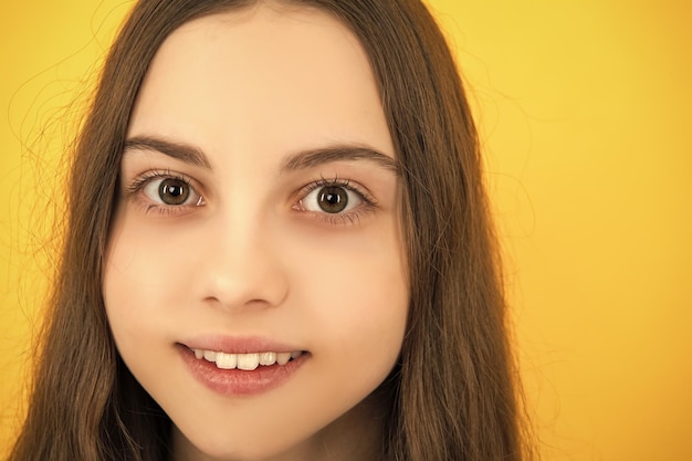 Close-up portret van kaukasisch tienermeisje Hoofdschot van schattig tienerkind op gele geïsoleerde studioachtergrond