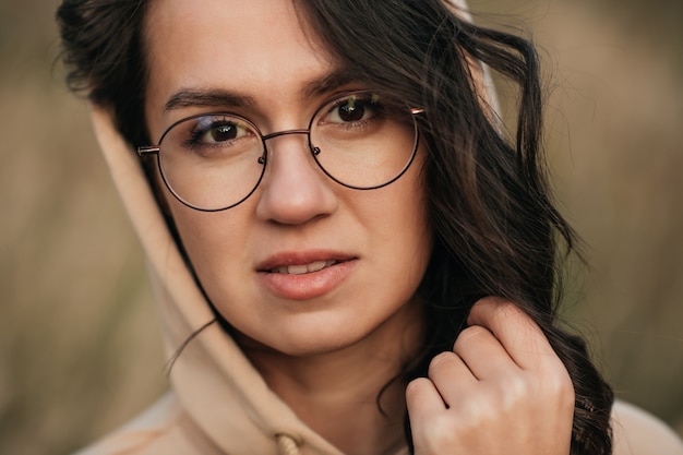 close-up portret van lachende brunette meisje in glazen en kap