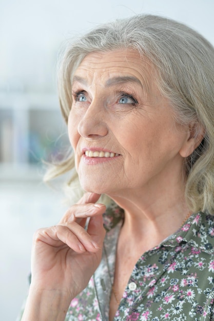 Close-up portret van lachende mooie senior vrouw poseren thuis