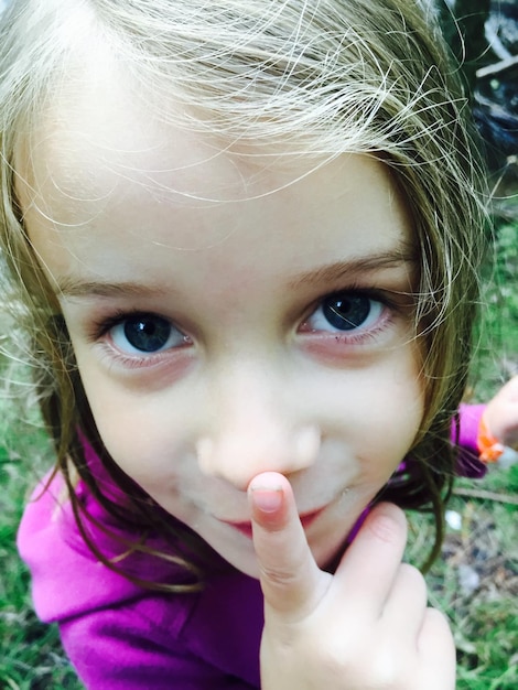 Foto close-up portret van meisje met vinger op lippen op het veld