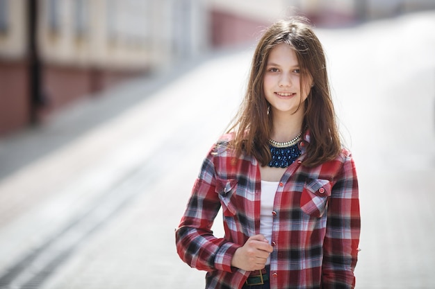 Close-up portret van mooi meisje tiener in heldere plaid shirt in stedelijke straat achtergrond