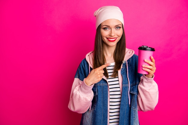 Close-up portret van mooie aantrekkelijke mooie charmante vrolijke vrolijk meisje in de hand houden koffie papieren beker nieuwe smaak aanbevelen geïsoleerd op heldere levendige glans levendige roze fuchsia kleur