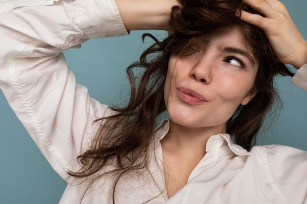 Close-up portret van positieve aantrekkelijke gekke vrolijke grappige jonge krullende brunette vrouw geïsoleerd op