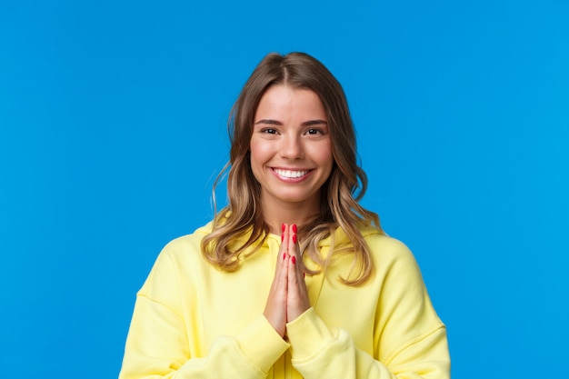 Close-up portret van schattig vrolijk lachend blond meisje met kort haar, handen samen in namaste of bidden gebaar, dank voor hulp, namaste gebaar buigen, dankbaar staan