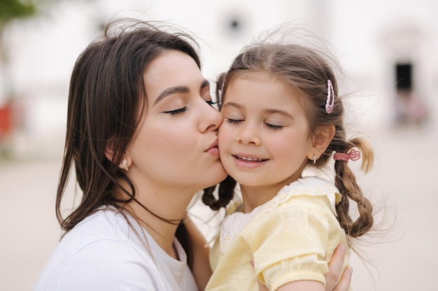 Close-up portret van schattige dochter met mooie moeder vrouw kus haar dochter