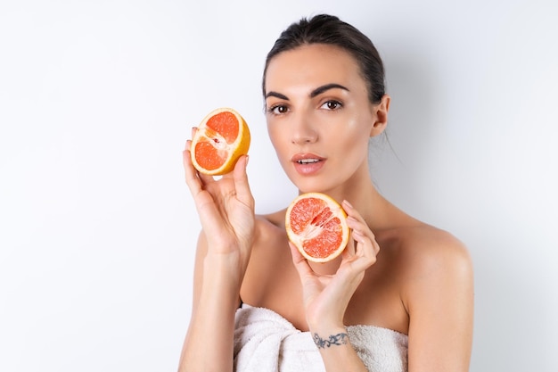 Close-up portret van topless vrouw met perfecte huid en natuurlijke make-up vol naakte lippen met verse citrus vitamine C grapefruitx9