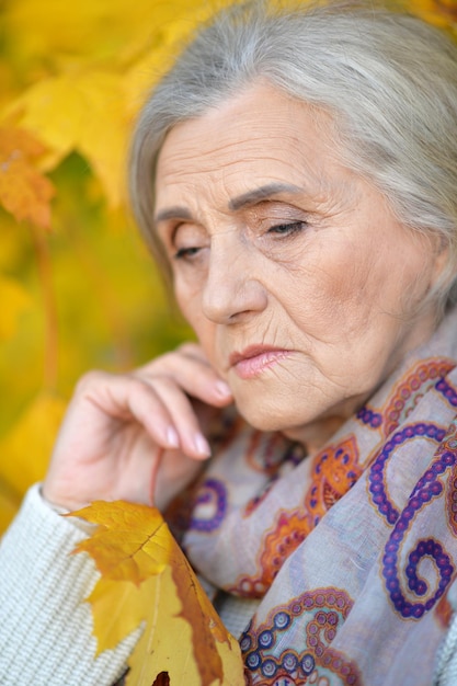 Close-up portret van trieste senior vrouw in herfst park