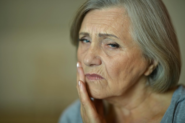 Close-up portret van trieste senior vrouw met kiespijn