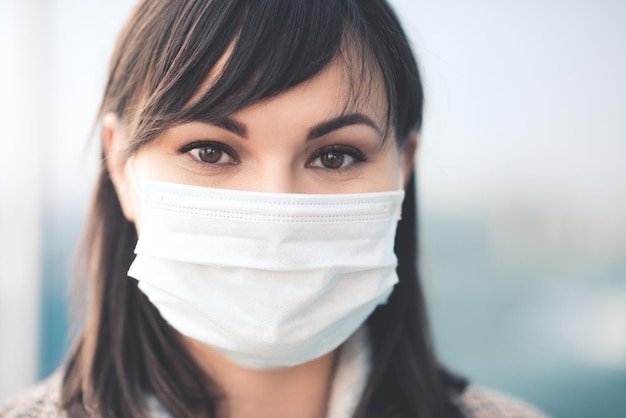 Close-up portret van volwassen vrouw die medisch masker draagt