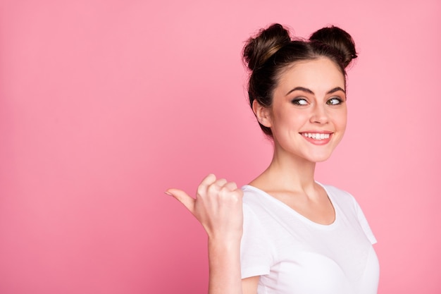 Close-up portret van vrolijk meisje wijzende duim weergegeven: advertentie geïsoleerd over roze kleur background