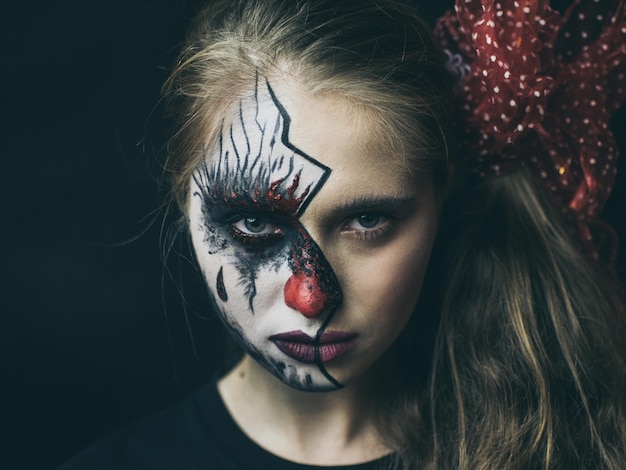 Close-up portret van vrouw met geschilderd gezicht op zwarte achtergrond