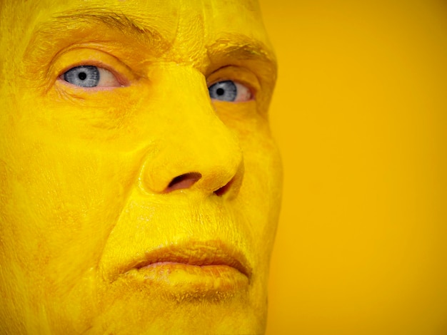 Close-up portret van vrouw met gezicht verf tegen gele achtergrond