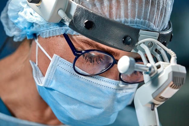 Close-up portret van vrouwelijke chirurg arts die beschermend masker en hoed draagt tijdens de operatie Gezondheidszorg medisch onderwijs chirurgie concept