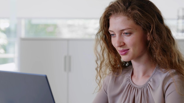 Close-up portret van zakenvrouw zittend op de werkplek op kantoor typen en kijken naar pc-scherm