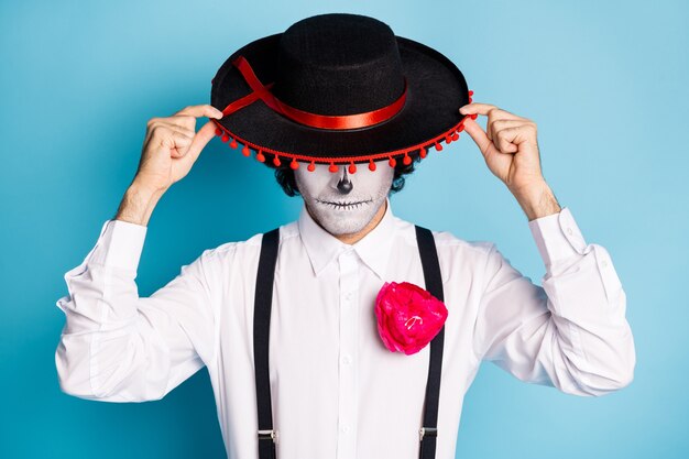 Close-up portret van zijn knappe enge griezelige verdachte stijlvolle man heer dragen sombrero verbergen gezicht Santa Muerte carnaval geïsoleerd helder levendig glans levendige blauwe kleur achtergrond