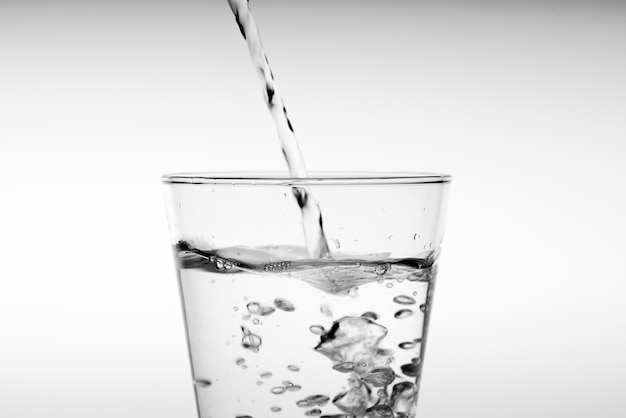 Close up pouring drinking water into glass