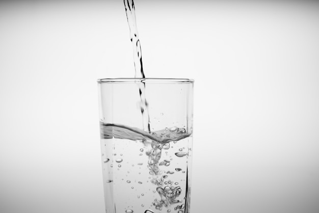 Close up pouring drinking water into glass