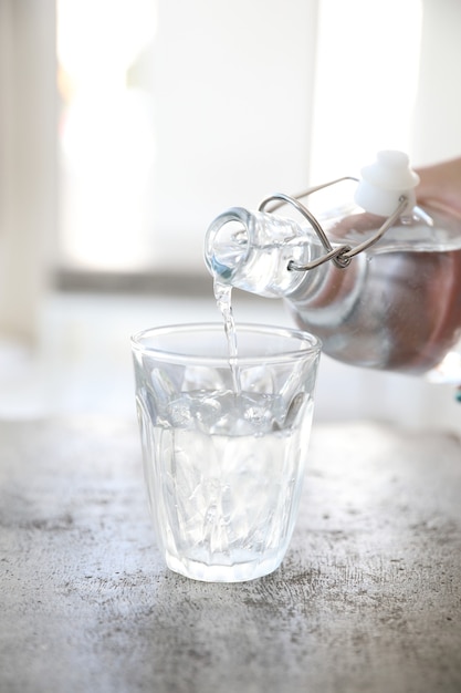 Close up pouring water to glass