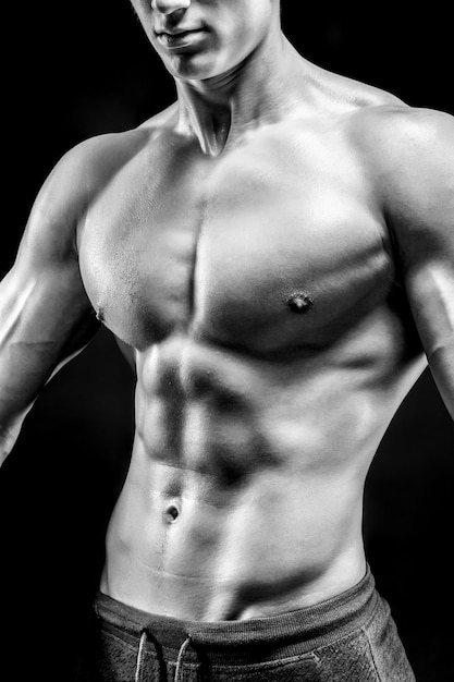 Close-up of a power fitness man on black background