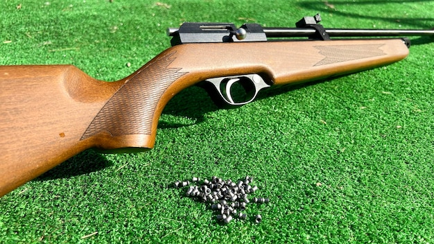 Close up of a practice rifle with lead ammunition on artificial grass