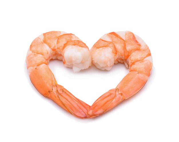 Photo close-up of prawns in heart shape over white background