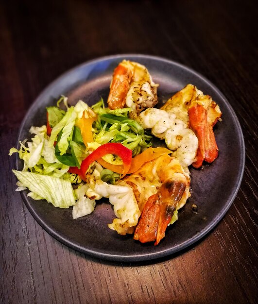 Photo close-up of prawns served in plate on table