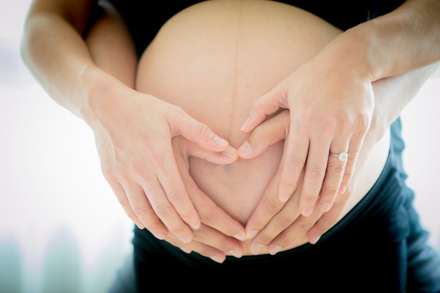 Close up on pregnant belly and with husband hand