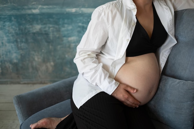 Крупный план беременной женщины, держащей живот