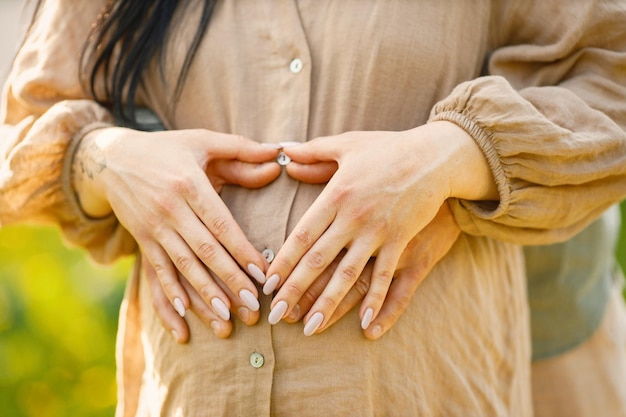 Close up of pregnant woman and her husband hugging the belly