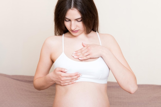 Close Up of pregnant women having painful feelings in breast Woman checking her breast for cancer