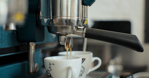 Close up prepare double shot of espresso coffee, slow motion. Barista preparing an espresso coffee in a bar.