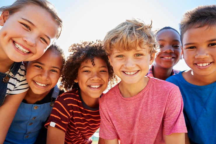 Photo close up of preteen friends in a park smiling to camera