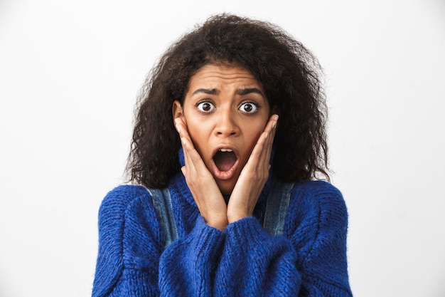 Close up of a pretty excited young african woman wearing sweater standing isolated, screaming