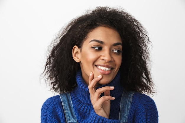 Close up of a pretty young african woman wearing sweater standing isolated, posing