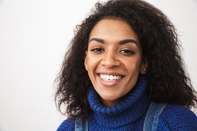 Close up of a pretty young african woman wearing sweater standing isolated, posing