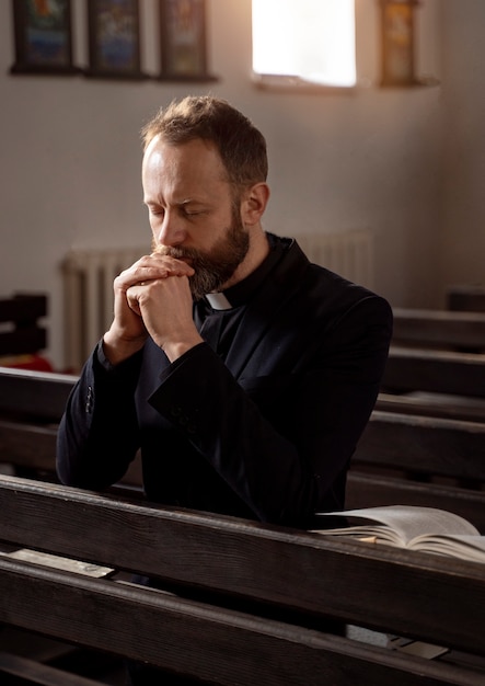 Крупный план молящегося священника
