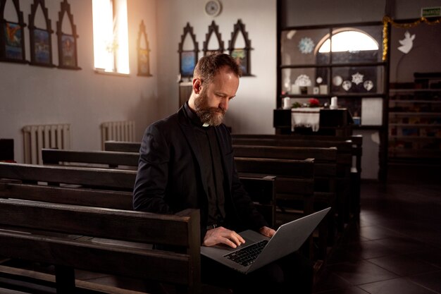 Close up on priest using laptop