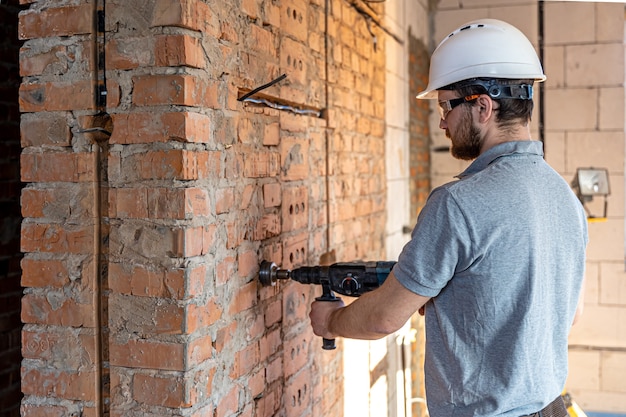 Close-up of the process of drilling a brick wall at a construction site