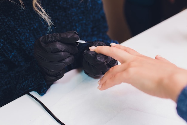 Foto chiuda in su del manicure trattato della francia al salone di bellezza.