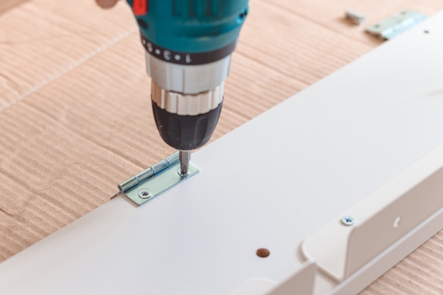 Close-up of the process of installation a furniture  with electric screwdriver