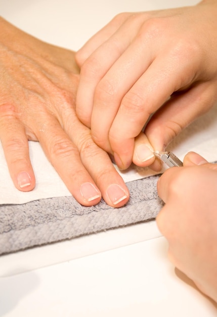 Photo close up of process of manicure at beauty salon