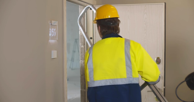 Photo close up of professional builder in uniform walking in renovating apartment
