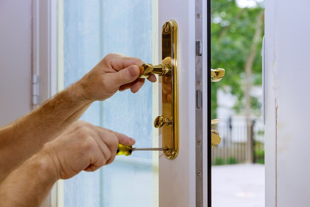 Close up of a professional locksmith installing or repairing a new deadbolt lock