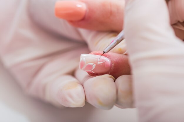 Close-up of professional manicurist beautifying a client's hands.