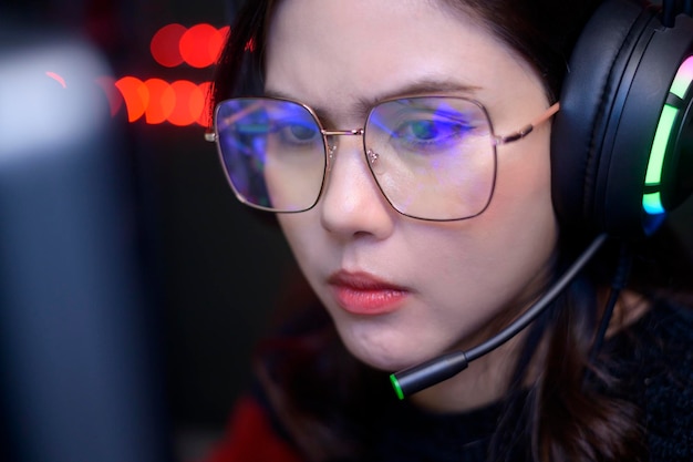 Close up of professional Streamer and gamer wearing glasses playing online video games with monitor