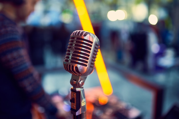 Close up of a professional vintage microphone with blurred lights