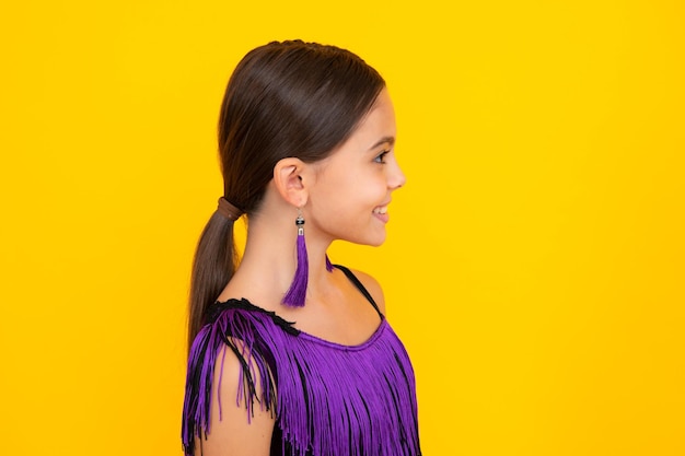 Close up profile portrait of caucasian teen girl head shot of cute teenager child on yellow isolated studio background