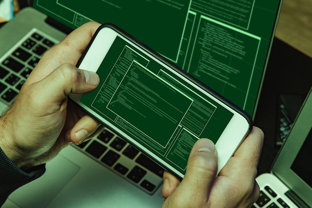 コードを入力するハッカーの手のプログラマーのクローズアップ