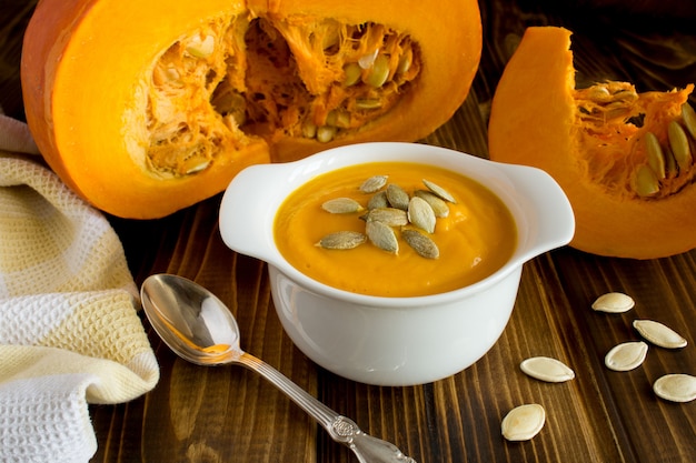 Close up on pumpkin soup in bowl with pumpkin seeds